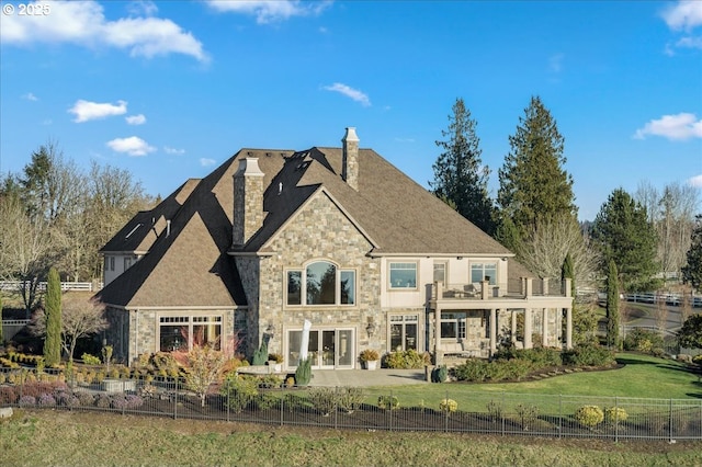 exterior space featuring french doors, a balcony, and a yard