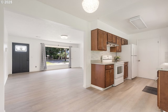 6139 SE 103rd Ave, Portland, OR 97266 - kitchen with white appliances, under cabinet range hood, light wood-type flooring, light countertops, and backsplash