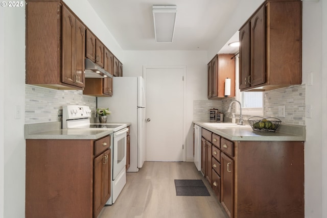 6139 SE 103rd Ave, Portland, OR 97266 - kitchen with white range with electric stovetop, under cabinet range hood, light wood-type flooring, backsplash, and light countertops