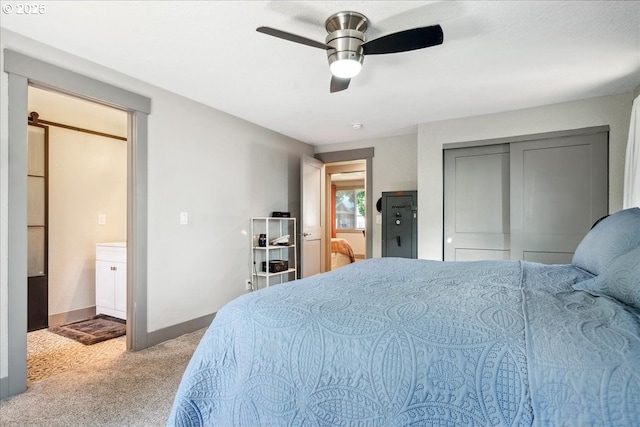 carpeted bedroom featuring baseboards, ceiling fan, ensuite bath, and a closet