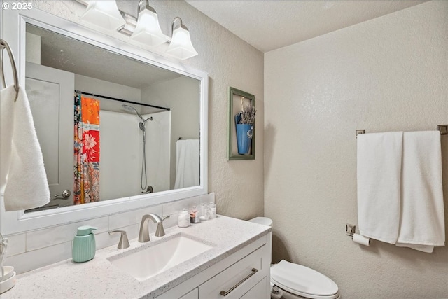 bathroom featuring a textured wall, vanity, toilet, and a shower with curtain