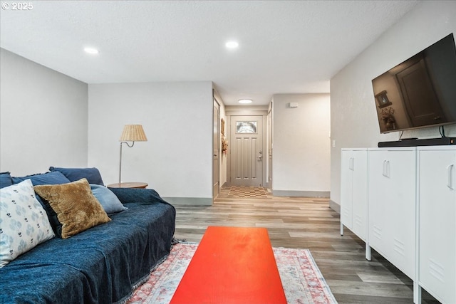living room featuring light wood-type flooring, recessed lighting, and baseboards