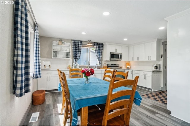 dining space with wood finished floors and recessed lighting