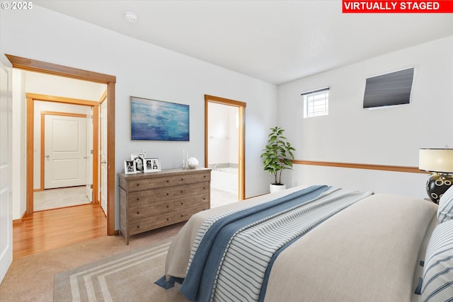 bedroom with ensuite bathroom and carpet floors