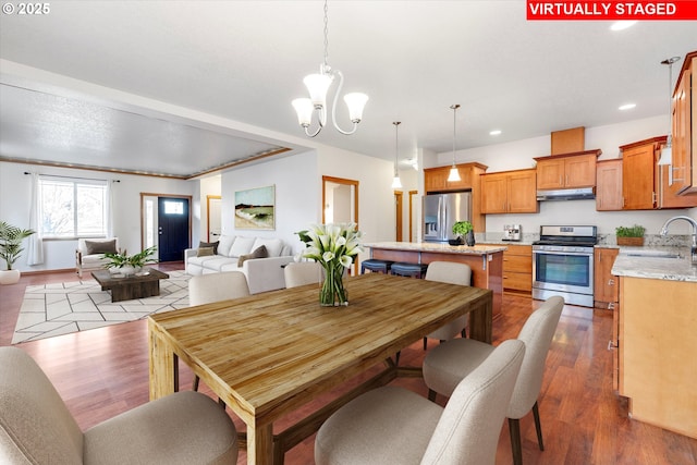 dining room with hardwood / wood-style floors, a chandelier, and sink