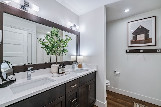 12703 NE 58th Ave, Vancouver, WA 98686 - full bathroom featuring wood finished floors, baseboards, toilet, double vanity, and recessed lighting