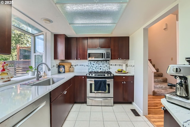 4388 NW Neskowin Ave, Portland, OR 97229 - kitchen featuring decorative backsplash, light countertops, a sink, appliances with stainless steel finishes, and light tile patterned floors