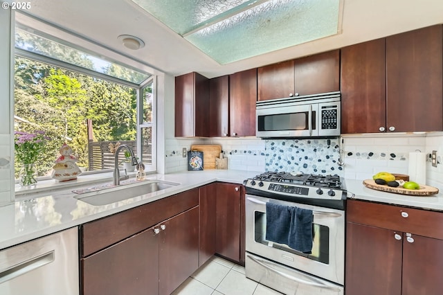4388 NW Neskowin Ave, Portland, OR 97229 - kitchen featuring decorative backsplash, a sink, light countertops, stainless steel appliances, and light tile patterned flooring