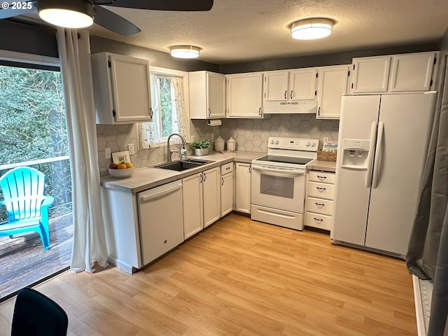 29640 SW Volley St Unit 39, Wilsonville, OR 97070 - kitchen with white appliances, a sink, under cabinet range hood, light wood-style flooring, and white cabinets