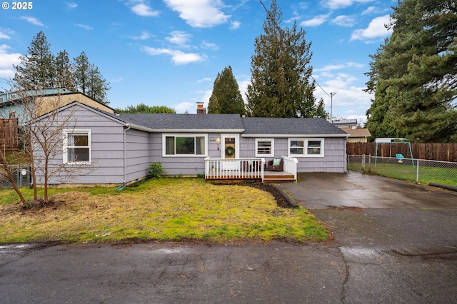 single story home with a chimney, roof with shingles, fence, a wooden deck, and a front yard