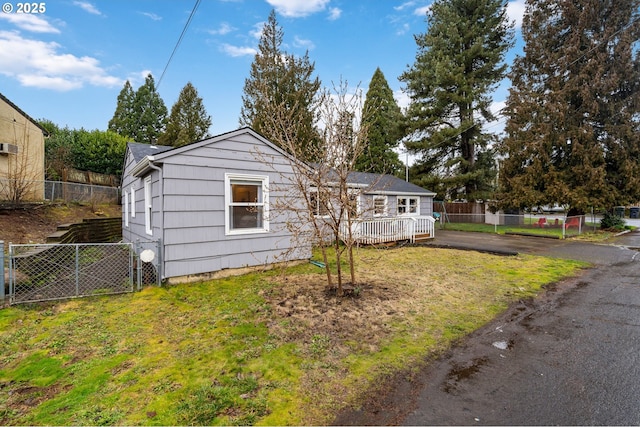 view of front of house featuring fence, a deck, and a front lawn