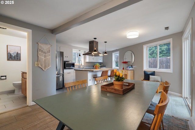 dining space featuring light wood finished floors, baseboards, and visible vents