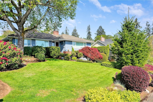 view of front of house featuring a front lawn and a chimney