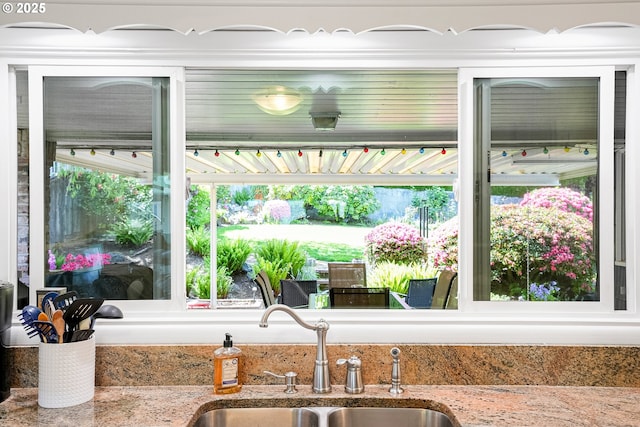 kitchen featuring a sink and light stone counters