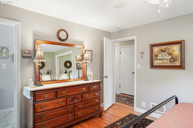 bedroom with light wood-style floors, baseboards, and a ceiling fan