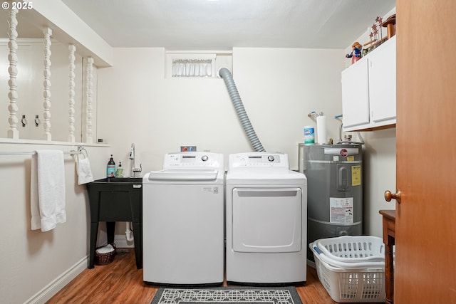 laundry area with cabinet space, water heater, independent washer and dryer, and light wood-type flooring