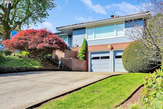 view of front facade featuring concrete driveway, an attached garage, and brick siding