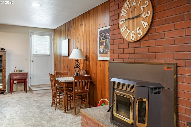 carpeted dining room featuring wood walls