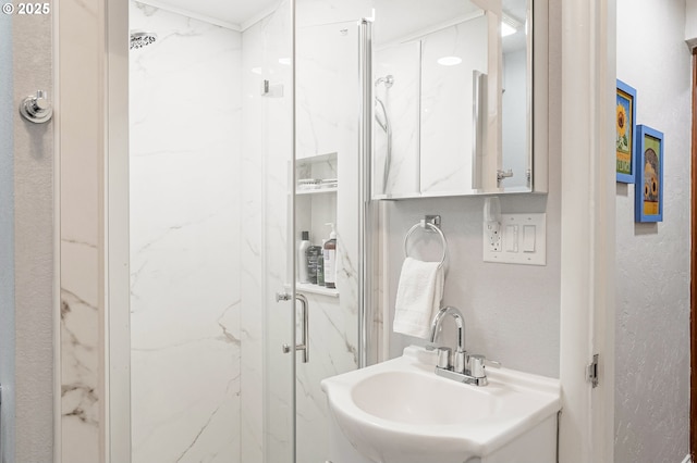 full bath with a sink and a marble finish shower