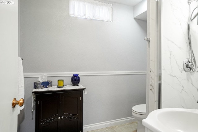 bathroom with toilet and baseboards