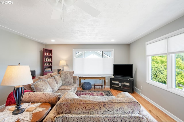living room with wood finished floors, a ceiling fan, baseboards, recessed lighting, and a textured ceiling