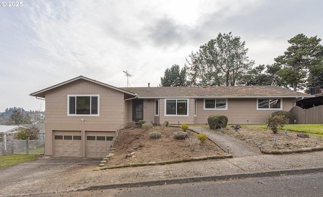 ranch-style home with driveway, an attached garage, and fence