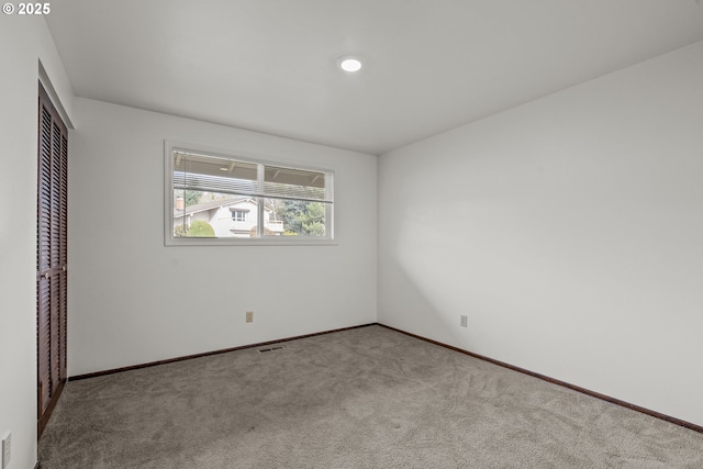 unfurnished bedroom featuring light carpet and a closet