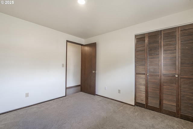 unfurnished bedroom featuring light colored carpet and a closet