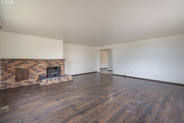 unfurnished living room featuring a fireplace and dark hardwood / wood-style flooring