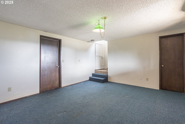 carpeted spare room featuring a textured ceiling