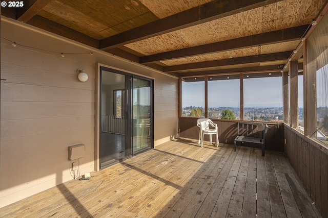 unfurnished sunroom featuring beam ceiling