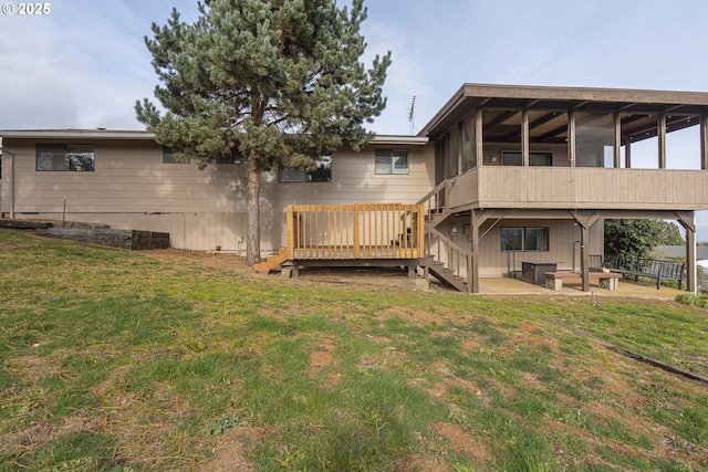 rear view of house featuring a deck, a patio area, a sunroom, and a lawn