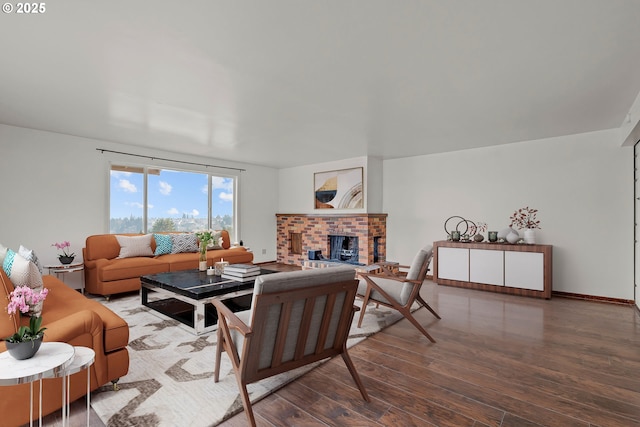 living area with a fireplace, baseboards, and wood finished floors