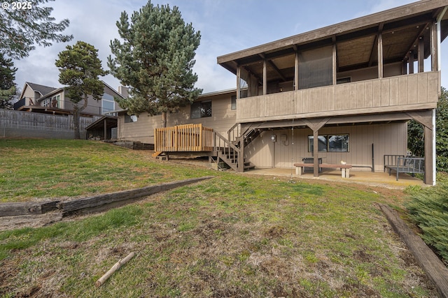 back of property with a patio, a wooden deck, and a lawn