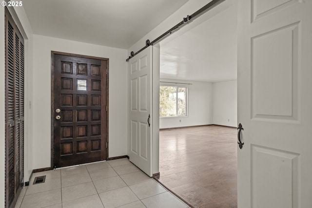 entrance foyer featuring light tile patterned flooring and a barn door