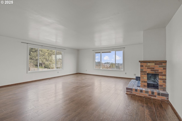 unfurnished living room featuring hardwood / wood-style flooring, a healthy amount of sunlight, and a fireplace