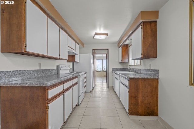 kitchen featuring light tile patterned floors, white appliances, sink, and white cabinets