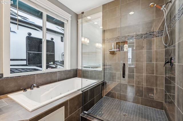 full bath with a jetted tub and tiled shower