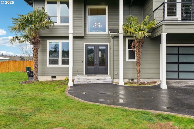 doorway to property with french doors, a yard, crawl space, fence, and driveway