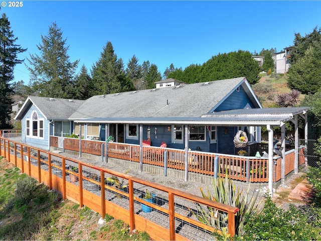 back of house with fence and a shingled roof