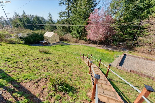 view of yard featuring a greenhouse and an outdoor structure