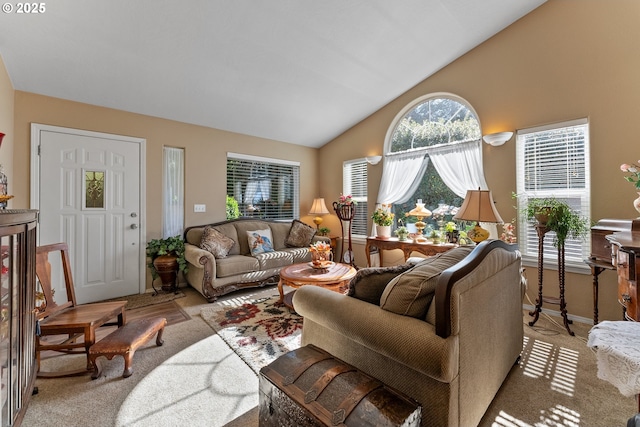 carpeted living area with baseboards and vaulted ceiling