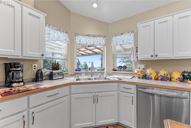 kitchen with dishwasher, light countertops, white cabinetry, and a sink