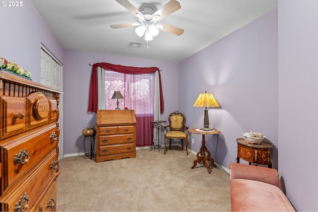 living area featuring visible vents, baseboards, carpet, and a ceiling fan