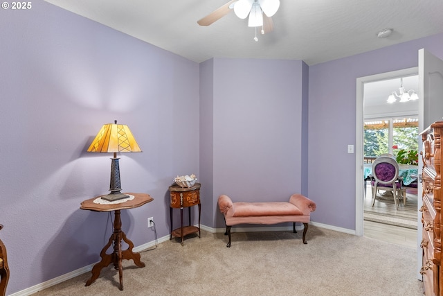 sitting room with carpet flooring, ceiling fan with notable chandelier, and baseboards