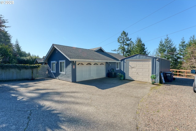 detached garage featuring fence and central AC