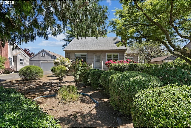 view of front of house featuring a garage and an outbuilding