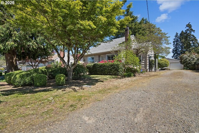 view of front of house featuring a chimney and an outdoor structure