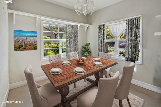 dining area featuring baseboards and a chandelier