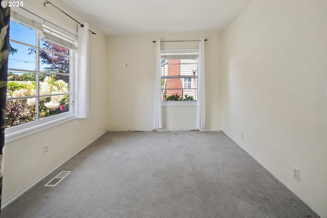 unfurnished living room with plenty of natural light, a high end fireplace, carpet flooring, and baseboards